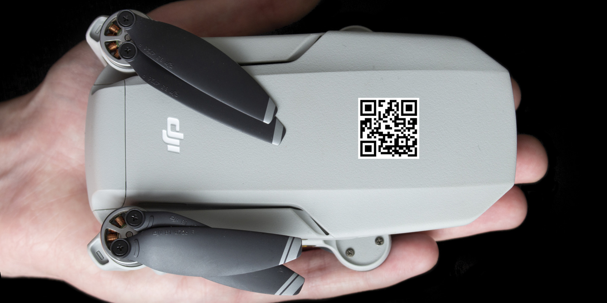 Drone med QR-kode som ligger i en hånd